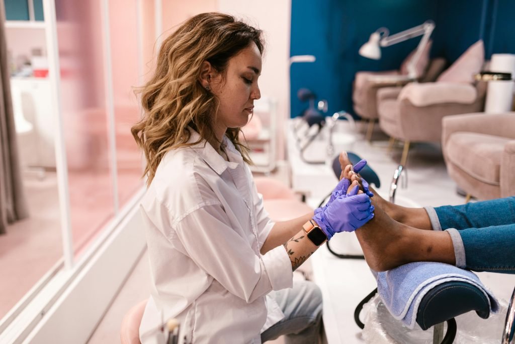 Woman giving pedicure treatment in a stylish modern salon. Beauty care focused.